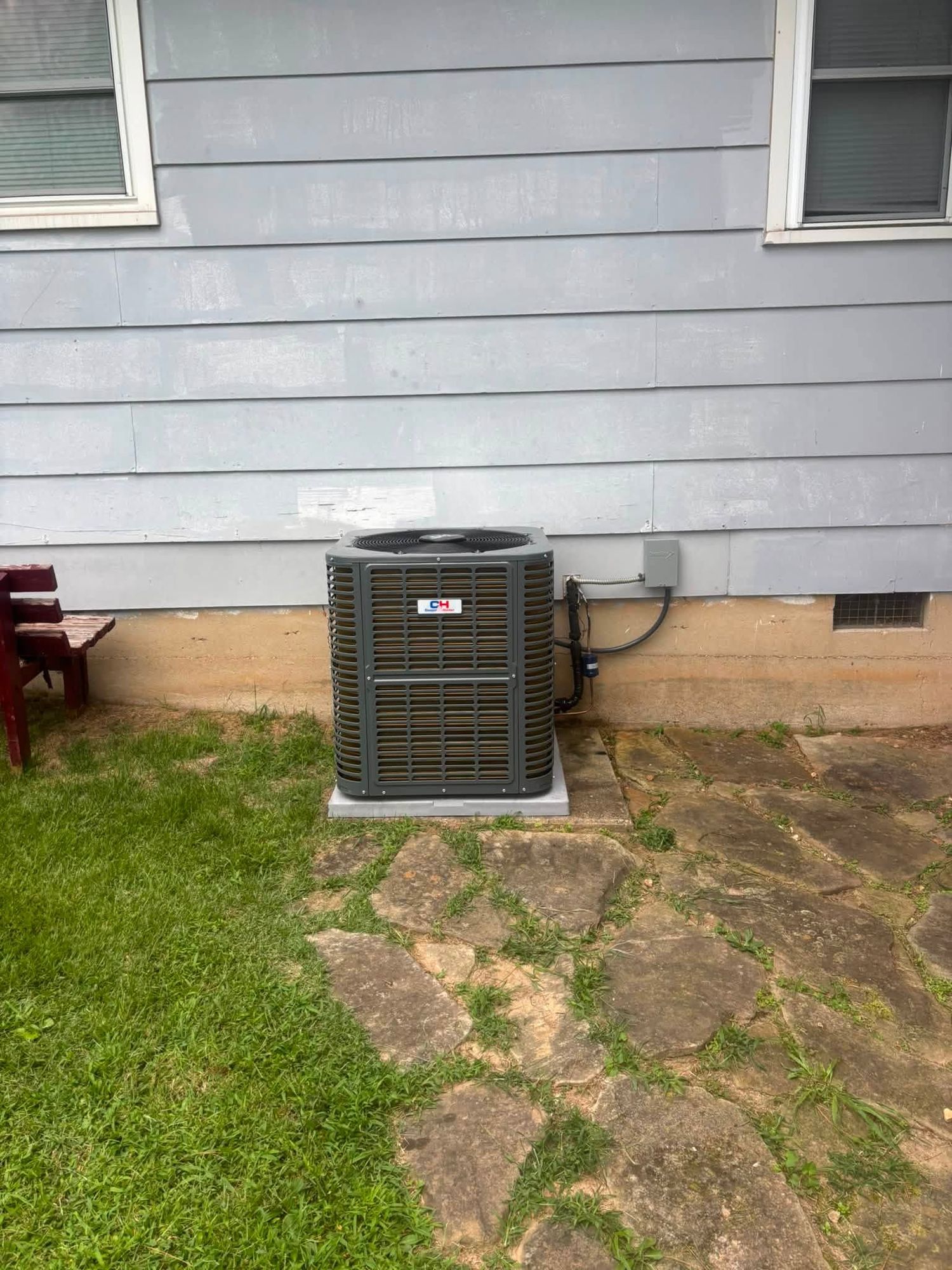 A finished Cooper & Hunter condenser installation against gray siding